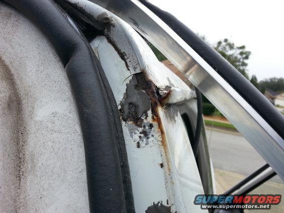 20131228_135434.jpg a shot from the back of the passenger side drip rail before I started cleaning it up..

the grey stuff is JB weld that I had used to cover up the screw holes from my old soft top..