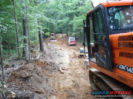 driveway28.jpg When the electrician & gas company left July 1, the trench was packed by a radio-controlled roller, and then grading began.