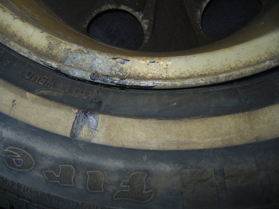 dscn3058tire1newtarrygooonbeadsidewall.jpg Used tire purchased from and installed by Tires and More for Less in NE Minneapolis on 03May2016, pic03.  Another photo of the flat tire, taken in the trunk of my car, showing more of the fresh tar-like goo which the tire store had smeared onto both the sidewall and rim.