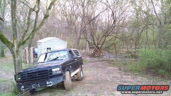 16327tree03.jpg Greg has been whining about this tree near his shed for a few years, so he was trying to pull it down with his Dodge's 12K (yeah, right) winch AND his ~35hp 4WD tractor for the past few days. Today (right before a rainstorm), he asked me to come help.  The strap was already tangled in the tree, so I just hooked onto it with a chain from my draw bar.  My 12K winch is going to the base of a tree in front, so I can also use the tires to pull.