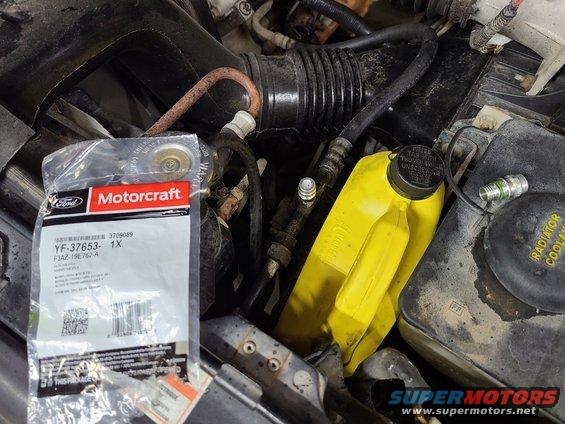 20210126_181826.jpg The A/C leak seems to have been from the high-side fitting. The (abandoned) alarm speaker was removed so a water bottle can be stored near the radiator until the timing cover gasket can be replaced.