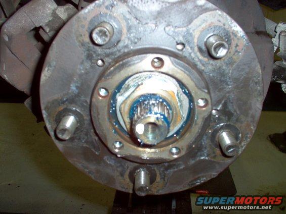 73-finished.jpg Look past the folded area to see where the inner nut's flats are, and fold the ring inward over one of them.  Reinstall the caliper, brakes, drive flange, & stub axle snap-ring and dust cap.

The rotor should have been on the hub already.  I had to backtrack.