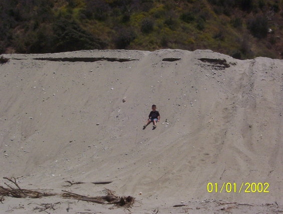 000_1472.jpg son playing on sand hill.