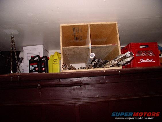 img_0005.jpg My Dad made up this divided box out of plywood to stick above the door on the shelf that runs the entire width of the garage, over the overhead door. This space would normally be dead, wasted space. The 4 hole box will be used for long stuff that I rarely use.