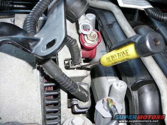 alternator-harness-removal.jpg Step 7:

With the Alternator bracket unbolted, you now have easier access to the alternator wiring.  Remove the 10mm nut  and remove the wire. Replace the nut.  With a VERY small screwdriver, insert it down into the other 2 harnesses located under the alternator bracket. Gently pry back on the locking clip and pull harness assemblies loose. remove all 3 harnesses and  tuck them back out of the way. YOU MAY NOW CAREFULLY REMOVE THE SPARK PLUG WIRE ASSEMBLY AND SET ASIDE.