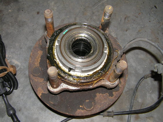 p1250003.jpg The old hub assembly. Notice the 4 studs (threaded on each end). The studs feed through the holes in the steering knuckle and have 4 bolts to fasten the hub assembly to the knuckle. Tighten 2 nuts on the same end in order to remove these studs.