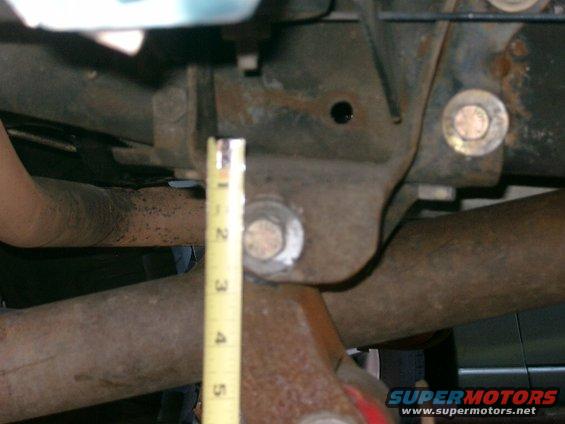 imgp0265.jpg Another shot of the rear hanger, image out of foucus but it shows the center of where we redrilled the stock hanger.  Looks like about 2" from the lip of the hanger to the center of the bolt.