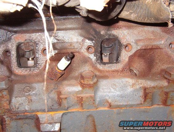 09leakhd.jpg This shows the true extent of the problem caused by the gaskets.  Notice the #4 port to the Left - it also has soot spots appearing on the head where the gasket material was breaking down.

The immediate effects of this leak were:
1) noise
2) risk of exhaust fumes (including Carbon monoxide) in the cabin
3) risk of heat damage to surrounding parts
4) excess air in the exhaust, causing the HEGO to report a false lean condition to the EEC, which compensated by running unnecessarily rich: lower economy, higher emissions, accelerated engine wear

[url=http://www.supermotors.net/registry/media/998125][img]http://www.supermotors.net/getfile/998125/thumbnail/stethoscope.jpg[/img][/url]

If it had been allowed to continue, it could have burned the valve or washed out the rings, causing catastrophic engine failure.  Those are probably among the reasons that Ford didn't put exhaust manifold gaskets on most of its engines.

Before ripping out any emissions systems, read [url=http://www.fourdoorbronco.com/board/showthread.php?5427-Emissions-Systems]this article[/url].

I didn't fix it on this truck, but the evaporator insulation hanging down in this pic can be replaced with a more-robust modern material, like this:

[url=http://www.supermotors.net/registry/media/964781][img]http://www.supermotors.net/getfile/964781/thumbnail/evapins.jpg[/img][/url]