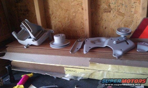 imag0114.jpg Bracketry after being sandblasted and primered. Left to right: smog pump bracket, water pump pulley, ac mounting bracket, ac tensionor bracket/ps mount, ps bracket